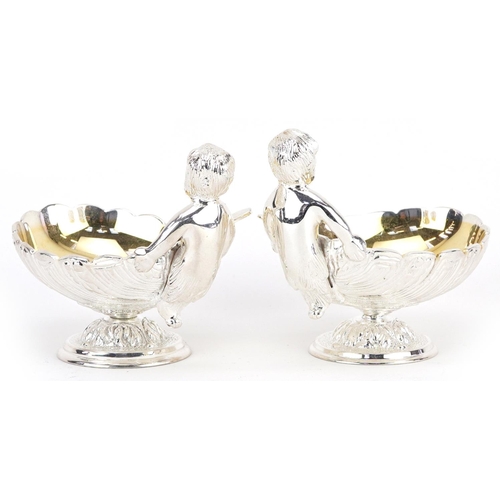 1506 - Pair of silver plated open salts in the form of Putti holding a seashell, 12cm in length