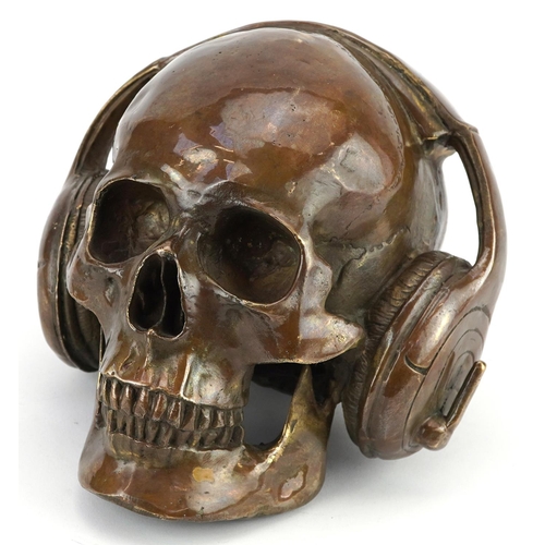 1450 - Steam punk interest patinated bronze model of a human skull wearing headphones, 20cm in length