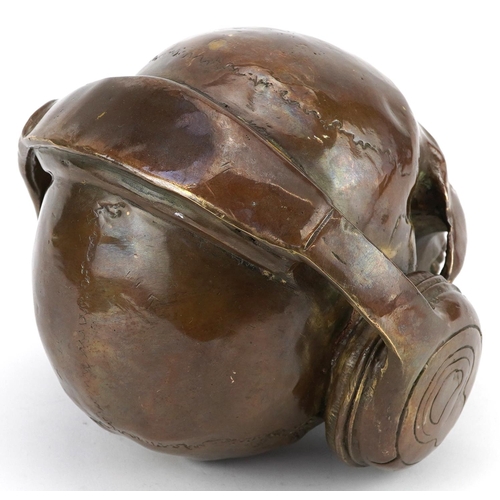 1450 - Steam punk interest patinated bronze model of a human skull wearing headphones, 20cm in length