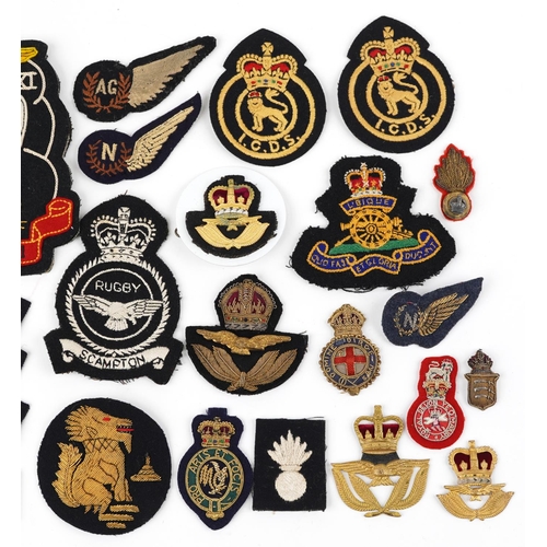 634 - Military interest cloth badges and shoulder titles including Air Gunner and Warden