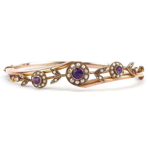 2064 - Victorian 9ct rose gold amethyst and seed pearl floral crossover hinged bangle housed in a velvet an... 