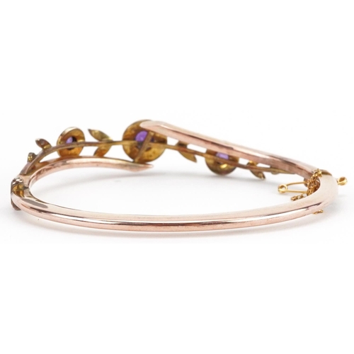 2064 - Victorian 9ct rose gold amethyst and seed pearl floral crossover hinged bangle housed in a velvet an... 