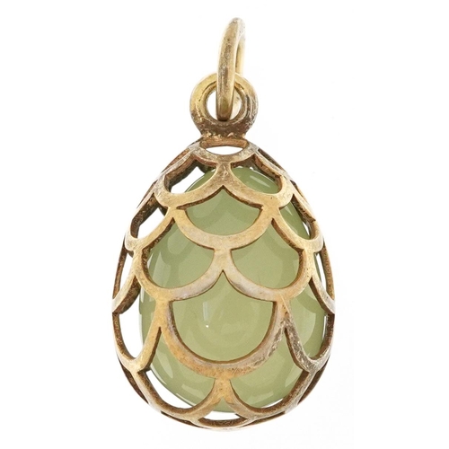 2538 - Silver gilt pierced cage pendant with enclosed green jade egg, impressed Russian marks to the suspen... 