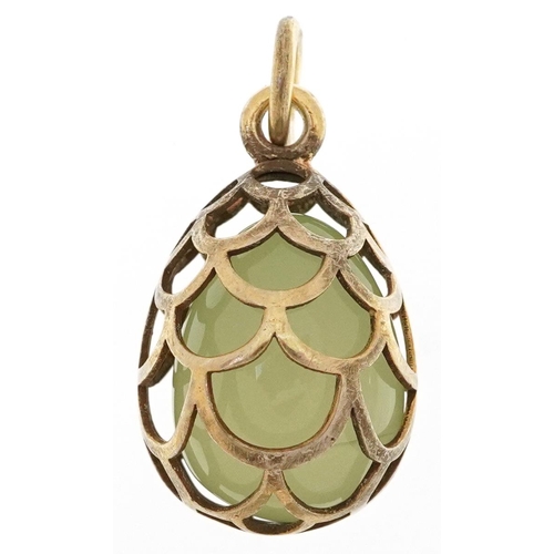 2538 - Silver gilt pierced cage pendant with enclosed green jade egg, impressed Russian marks to the suspen... 