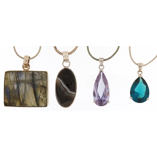 2688 - Four silver semi precious stone pendants on silver necklaces including amethyst and agate, the large... 