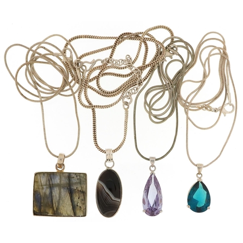 2688 - Four silver semi precious stone pendants on silver necklaces including amethyst and agate, the large... 