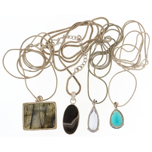 2688 - Four silver semi precious stone pendants on silver necklaces including amethyst and agate, the large... 