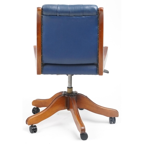 1038 - Mahogany and blue leather button back upholstered adjustable desk chair, 89cm high