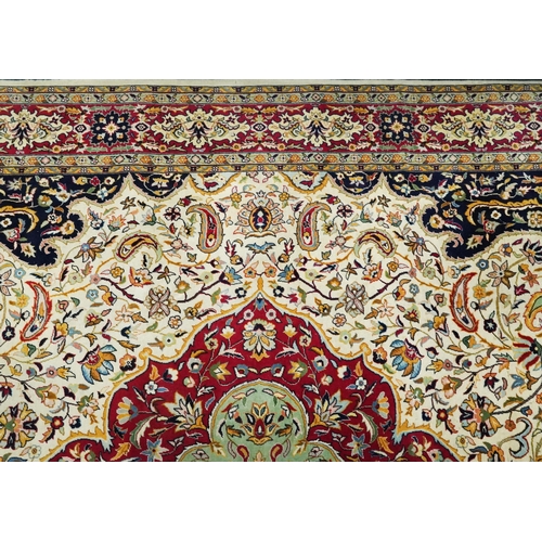 1106 - Rectangular Persian cream and red ground rug having an all over repeat floral design, 370cm x 270cm