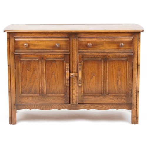 1009 - Ercol elm sideboard fitted with two drawers above a pair of cupboard doors, 85cm H x 122cm W x 48cm ... 