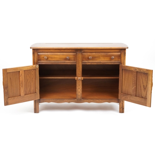 1009 - Ercol elm sideboard fitted with two drawers above a pair of cupboard doors, 85cm H x 122cm W x 48cm ... 