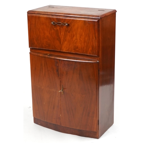 1069 - Art Deco walnut cocktail cabinet fitted with a fall enclosing a mirrored interior above a cupboard b... 