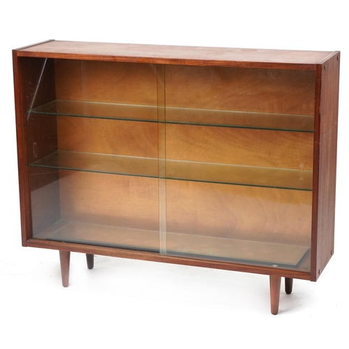 1070 - Mid century teak bookcase fitted with two sliding glass doors enclosing two adjustable glass shelves... 