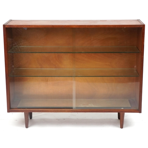 1070 - Mid century teak bookcase fitted with two sliding glass doors enclosing two adjustable glass shelves... 