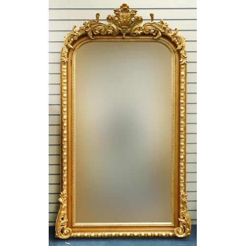 1110 - Large ornate gilt framed wall mirror having bevelled glass mounted with flowers and foliage, 220cm x... 