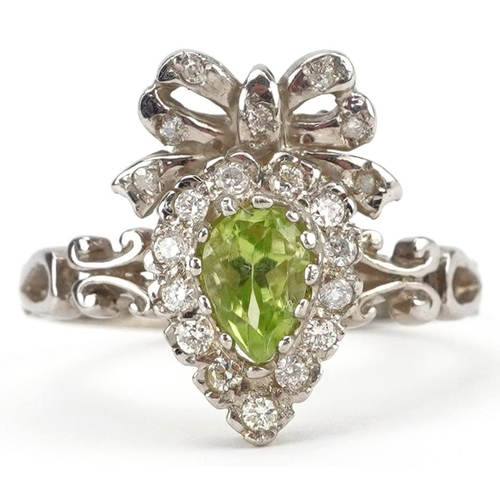 2229 - 9ct gold teardrop peridot and round brilliant cut diamond ring in the form of a bow, total diamond w... 