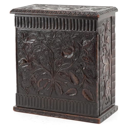 19th century oak table top collector's chest finely and profusely carved with foliage having hinged door enclosing five drawers, 22cm H x 20cm W x 10cm D