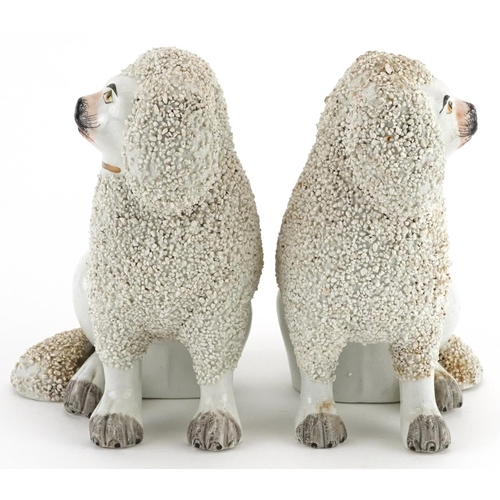 477 - Pair of Victorian Staffordshire pottery Poodles, each 14cm high