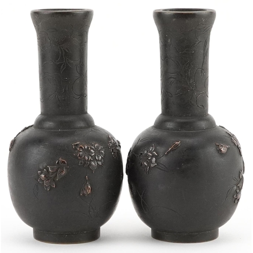 434 - Pair of Japanese bronze vases cast in relief with birds of paradise amongst flowers, each 12cm high