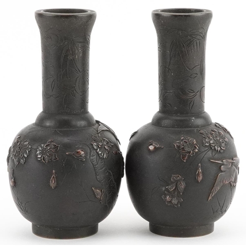 434 - Pair of Japanese bronze vases cast in relief with birds of paradise amongst flowers, each 12cm high