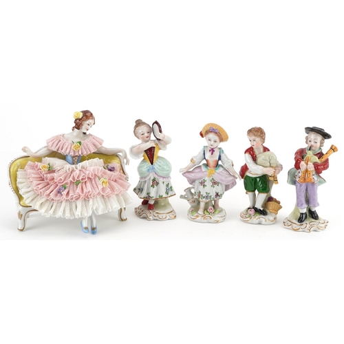 419 - German porcelain comprising four Dresden figurines and a lace figurine in the form of a female on se... 
