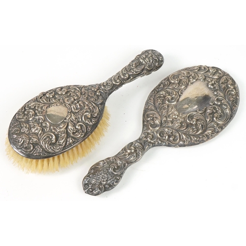 1319A - Victorian silver backed dressing table hand brush and similar mirror, each profusely embossed with f... 