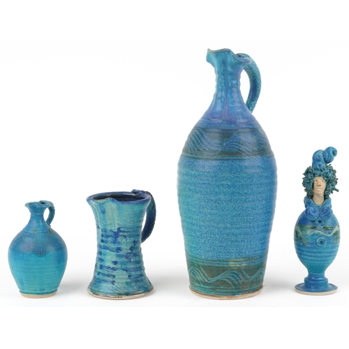 106 - Michael Kennedy, Irish blue glazed studio pottery comprising three jugs and a figural pot and cover,... 