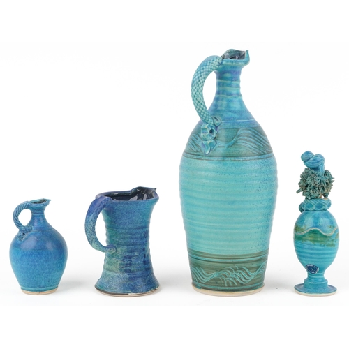 106 - Michael Kennedy, Irish blue glazed studio pottery comprising three jugs and a figural pot and cover,... 