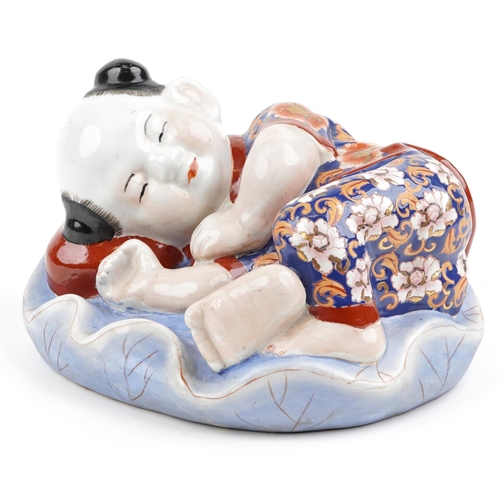 1339 - Chinese porcelain figure of a sleeping boy hand painted in the Imari palette, 24cm wide