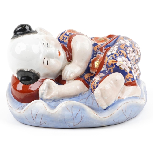 1339 - Chinese porcelain figure of a sleeping boy hand painted in the Imari palette, 24cm wide