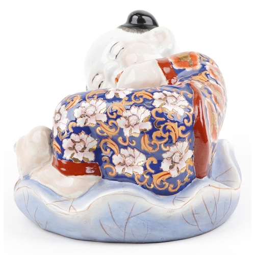 1339 - Chinese porcelain figure of a sleeping boy hand painted in the Imari palette, 24cm wide