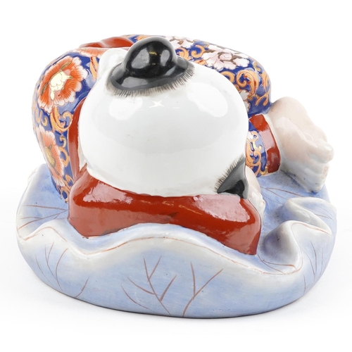 1339 - Chinese porcelain figure of a sleeping boy hand painted in the Imari palette, 24cm wide