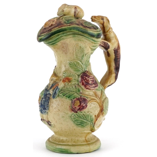 216 - 19th century Majolica lidded jug with handle in the form of a Greyhound, decorated in relief with a ... 