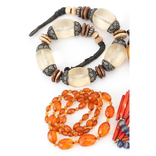 2809 - Six Asian necklaces including natural amber, amber coloured facetted beads and coral