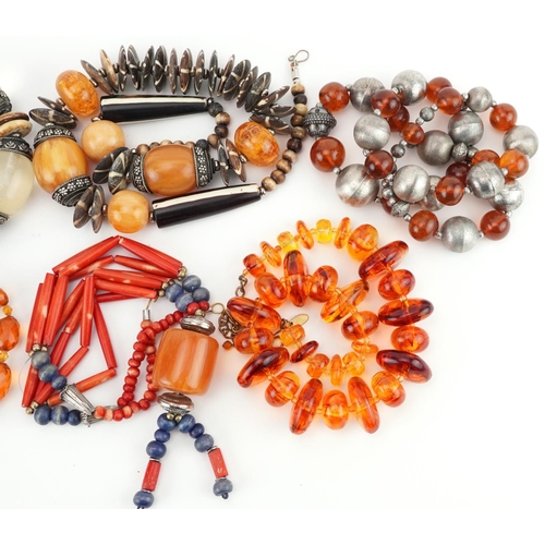 2809 - Six Asian necklaces including natural amber, amber coloured facetted beads and coral