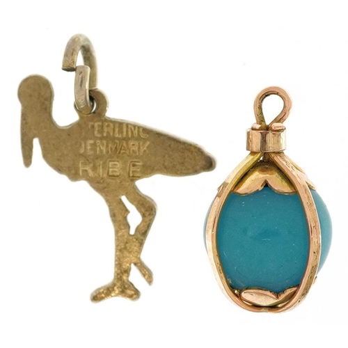 2526 - Two charms comprising Danish sterling silver and enamel stork from Ribe and an unmarked gold caged t... 