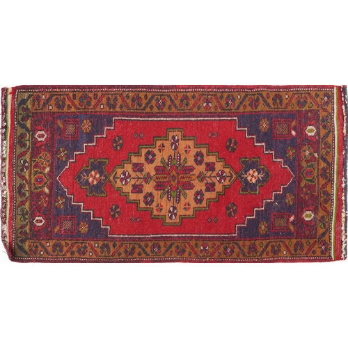 1220 - Rectangular Persian red and blue ground rug having an allover repeat floral design, 101cm x 52cm