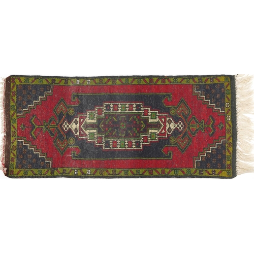 1219 - Rectangular Persian red and blue ground rug having an allover repeat floral design, 120cm x 53.5cm