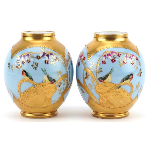 129 - Limoges, pair of French blue ground porcelain vases hand painted and gilded with stylised birds amon... 