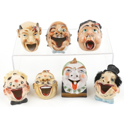 Seven early 20th century smoking interest Japanese porcelain ashtrays in the form of comical heads, one with Tilso paper label, the largest 11cm high