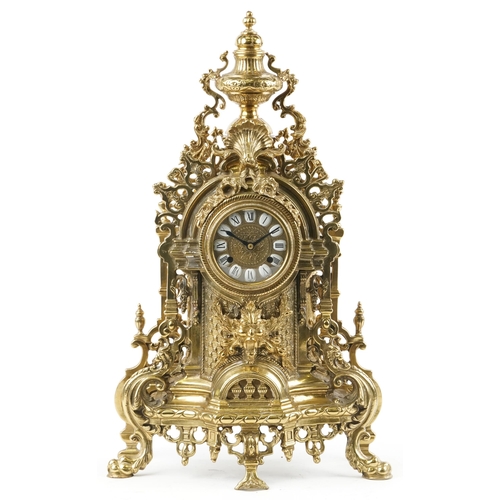 587 - Large 19th century style classical brass mantle clock with urn finial and mask having circular dial ... 