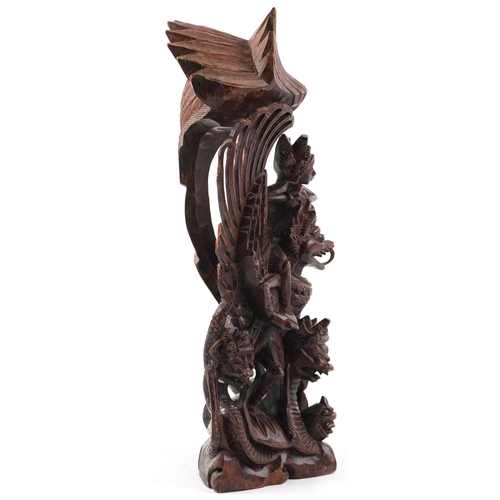 1468 - Large Burmese hardwood carving of a deity and mythical animals, 56cm high