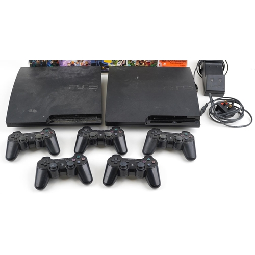 1597 - Two Sony PlayStation 3 games consoles with five controllers, docking station and games including Tom... 