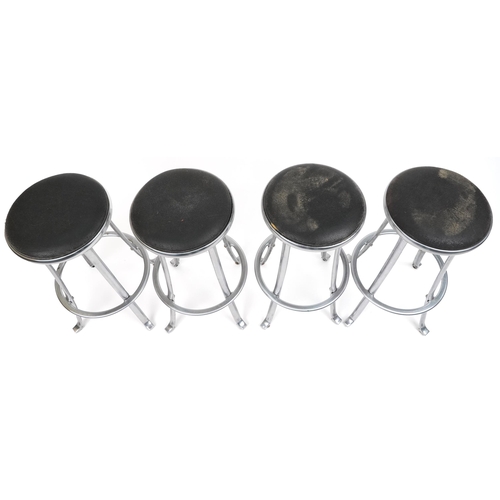 1173 - Set of four industrial chromed bar stools with black upholstered cushioned seats, 69cm high