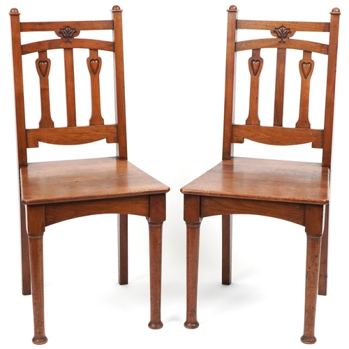 1060 - Pair of Arts & Crafts oak side chairs carved with hearts, 96cm high