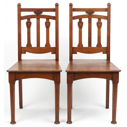 1060 - Pair of Arts & Crafts oak side chairs carved with hearts, 96cm high