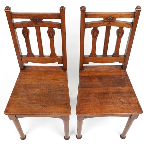 1060 - Pair of Arts & Crafts oak side chairs carved with hearts, 96cm high