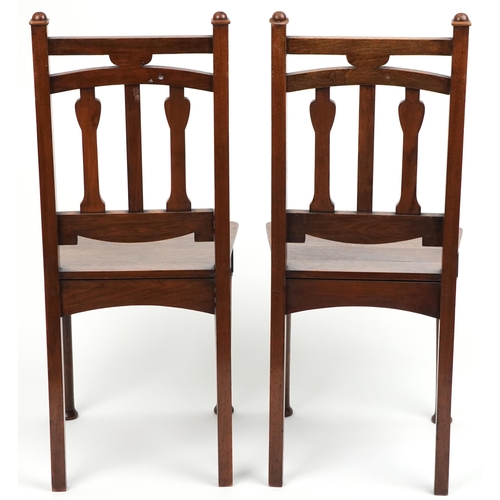 1060 - Pair of Arts & Crafts oak side chairs carved with hearts, 96cm high