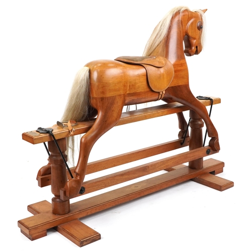 1127 - Large carved hardwood rocking horse with leather saddle on hardwood stand having brass plaque engrav... 