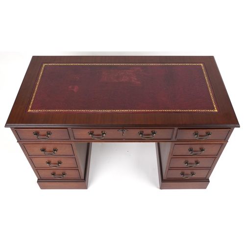 1111 - Mahogany twin pedestal desk with red tooled leather insert fitted with an arrangement of nine drawer... 